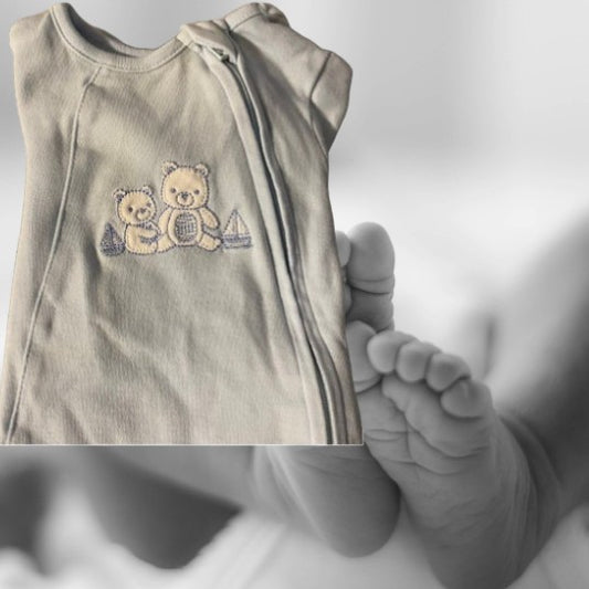 The Little Me Footed Appliqué Cotton Onesie features a charming bear appliqué design with boats