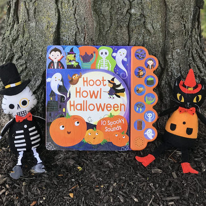 Halloween-themed book with sound effects next to Halloween decorations against a tree trunk.