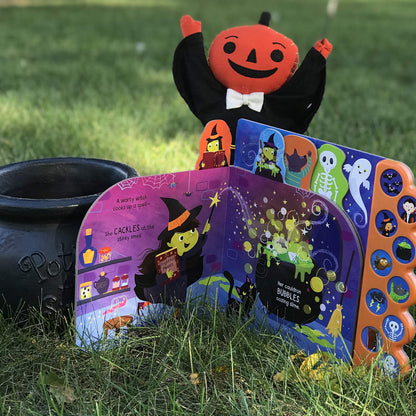 Halloween-themed children's book with colorful illustrations on a grassy background