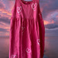 This girl's pink dress features a sleeveless design with a heart pattern making it a perfect dress for summer