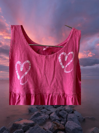 This girl's pink dress features a sleeveless design with a heart pattern making it a perfect dress for summer