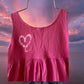 This girl's pink dress features a sleeveless design with a heart pattern making it a perfect dress for summer