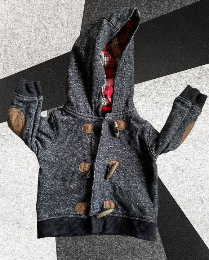 Baby sweater featuring a plaid lined hoodie with wooden toggle buttons