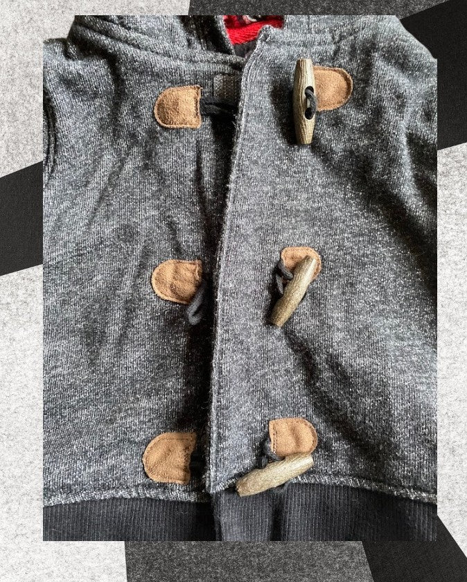 Baby sweater featuring a plaid lined hoodie with wooden toggle buttons