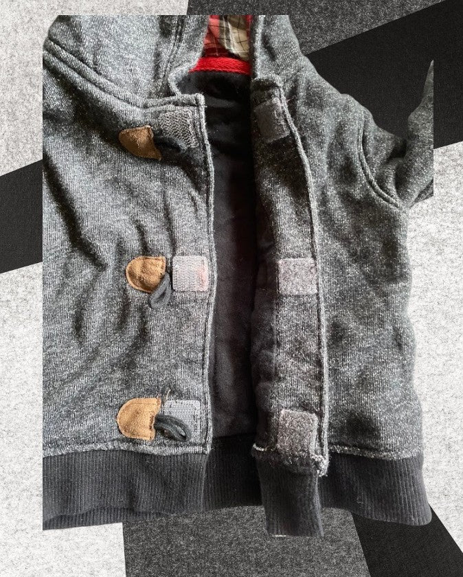 Baby sweater featuring a plaid lined hoodie with wooden toggle buttons