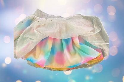 The Wonder Nation colorful reversible skirt features vibrant rainbow colors on one side and mesh with metallic dot designs on the other