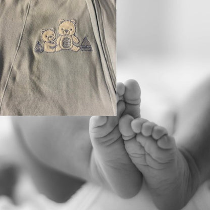 The Little Me Footed Appliqué Cotton Onesie features a charming bear appliqué design with boats