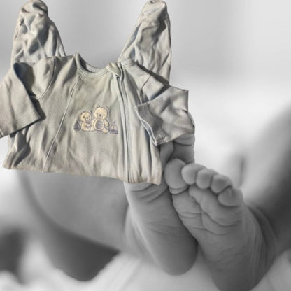 The Little Me Footed Appliqué Cotton Onesie features a charming bear appliqué design with boats